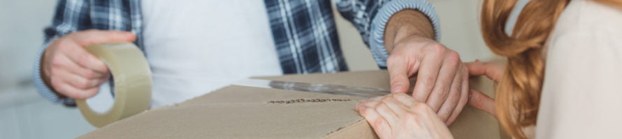 Couple packing a box to move house