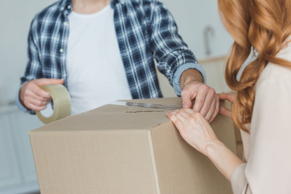 Couple packing a box to move house