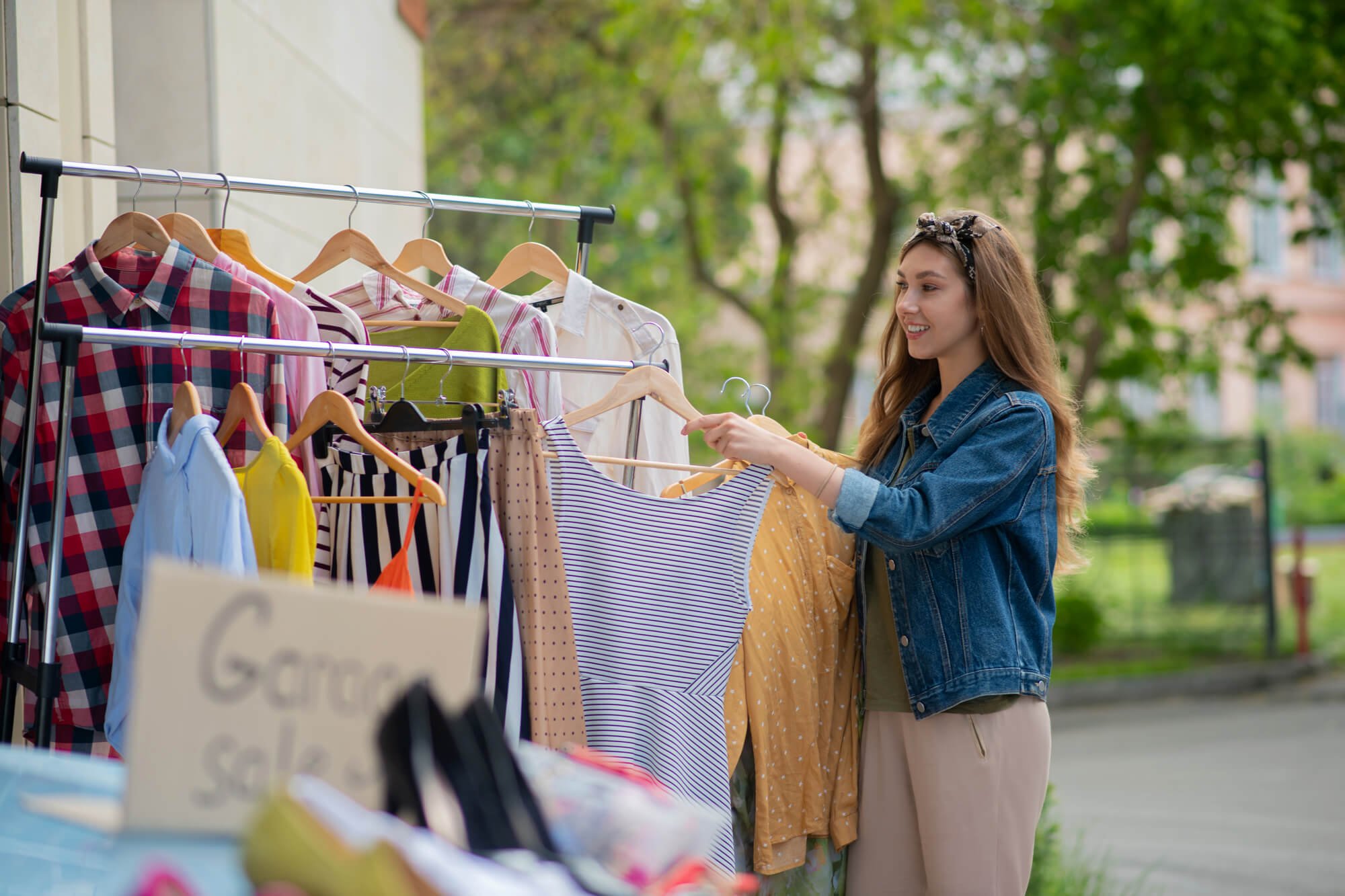 young woman shopping for dresses at garage sale